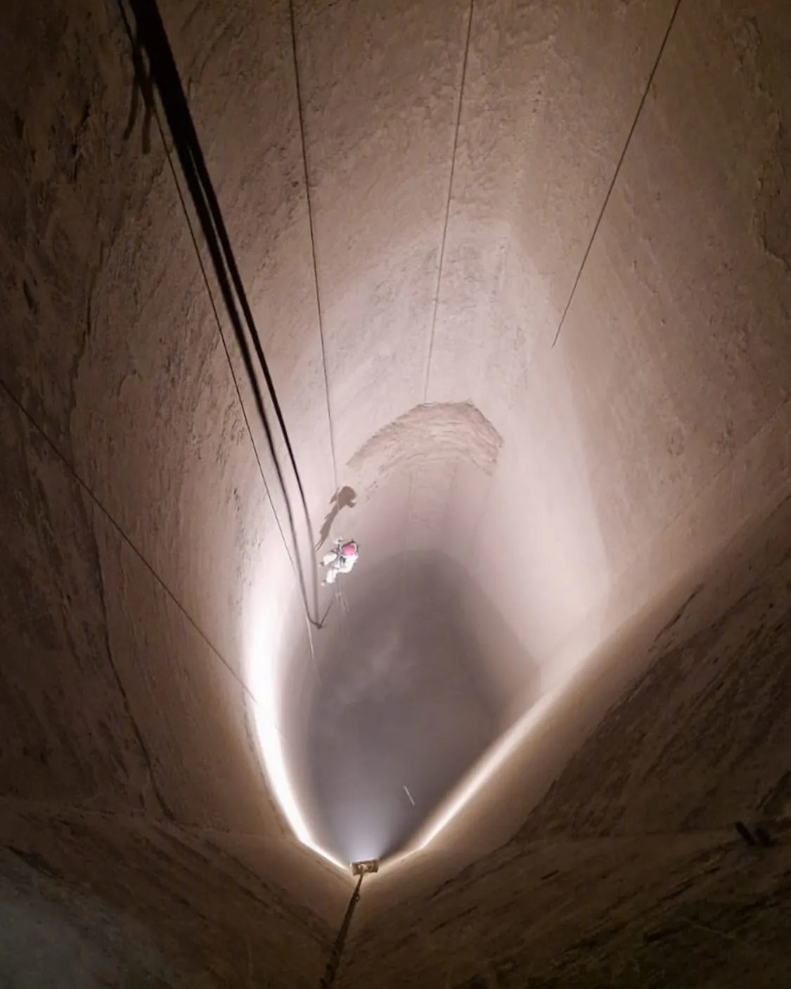 Industriekletterer seilt sich zur Reinigung in einen Silo ab