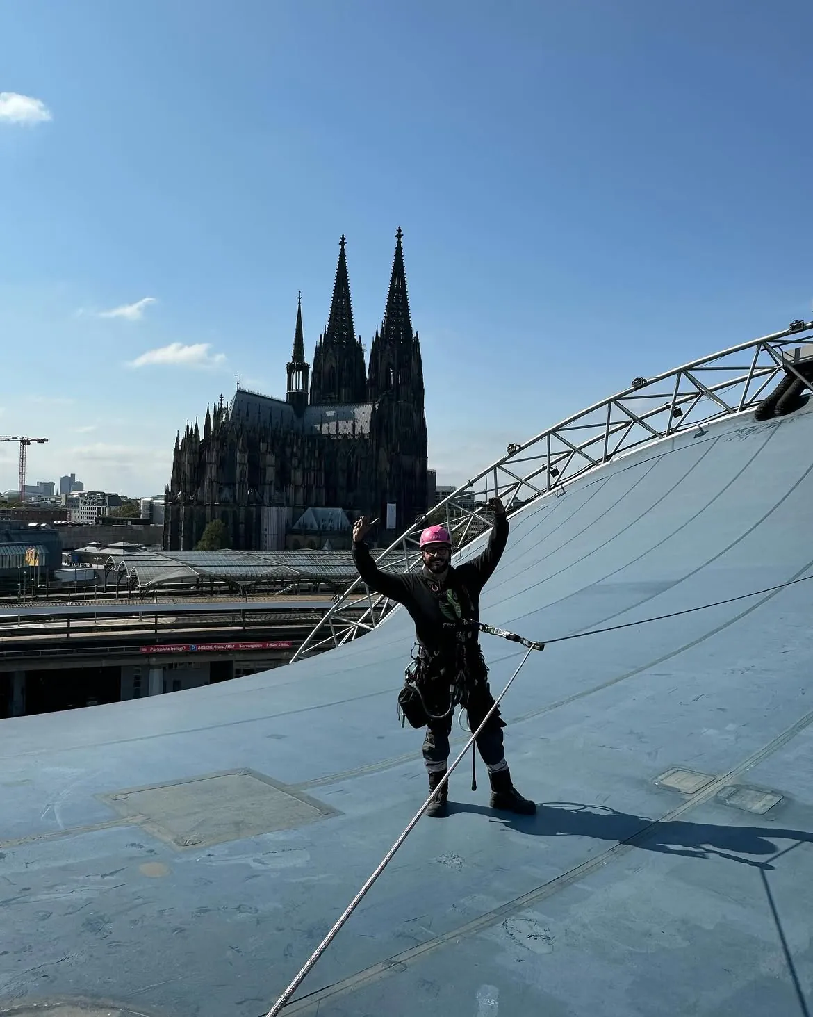 Industriekletterer im Seileinsatz auf dem Dach des Musical Dome in Köln, im Hintergrund der Kölner Dom